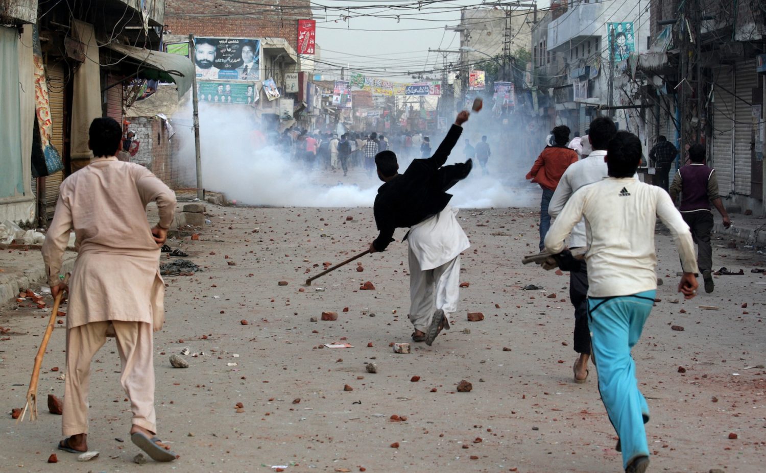 Pakistani protesters throw rocks during clashes with police to condemn Sunday's suicide bombings that struck two churches, in Lahore, Pakistan, Monday, March 16, 2015. Pakistani police fired tear gas on Monday after Christian protesters clashed with police in the eastern city of Lahore, a day after Taliban bombers killed more than a dozen people in suicide attacks on two churches in the city. (AP Photo/K.M. Chaudary)