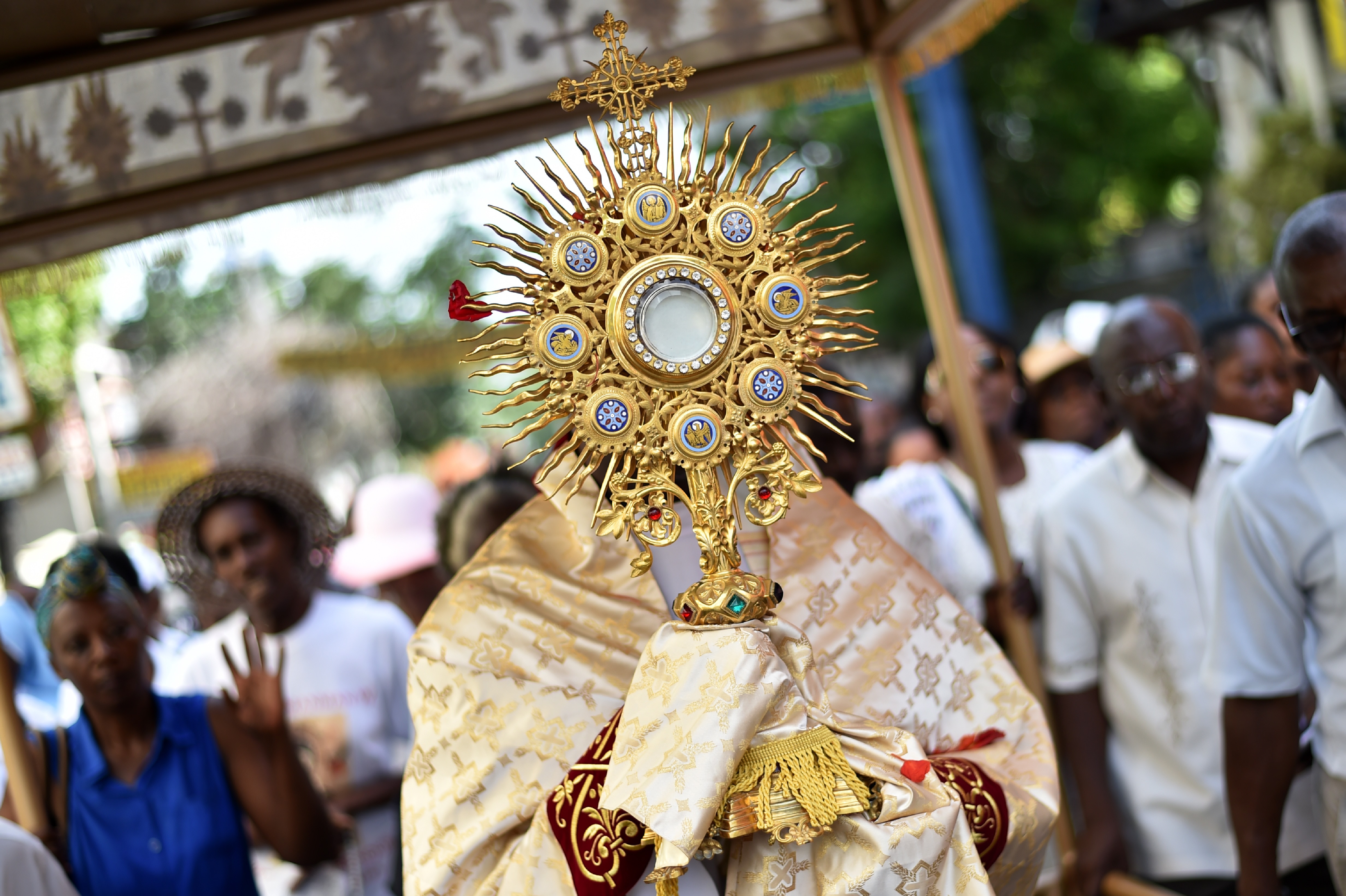 Catholic faithfuls participate in the Procession of the Feast of God (Procession de la Fete Dieu, in French) to mark the celebration of Corpus Christi, in the commune of Petion Ville, Port-au-Prince, on June 15, 2017.  / AFP PHOTO / HECTOR RETAMAL        (Photo credit should read HECTOR RETAMAL/AFP/Getty Images)
